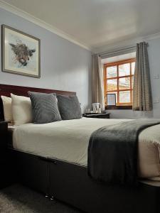 a large bed in a bedroom with a window at The Stag Hotel in Banchory