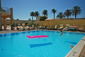 una persona che salta in una piscina con un giocattolo da piscina di Mahara Hotel & Wellness a Mazara del Vallo