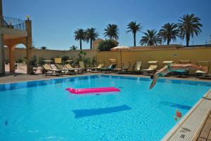 a person jumping into a swimming pool with a pool toy at Mahara Hotel & Wellness in Mazara del Vallo