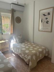 a small bedroom with a bed and a window at Casa Verano in Alicante +4 photos