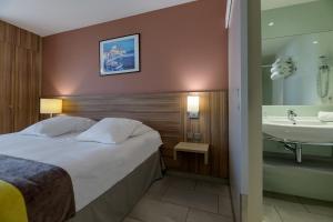 a hotel room with a bed and a sink at Best Western Plus Ajaccio Amirauté in Ajaccio