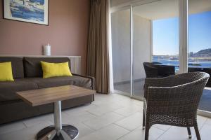 a living room with a couch and a table at Best Western Plus Ajaccio Amirauté in Ajaccio