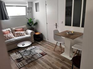 a living room with a couch and a table at Logement proche gare et Versailles in Marly-le-Roi
