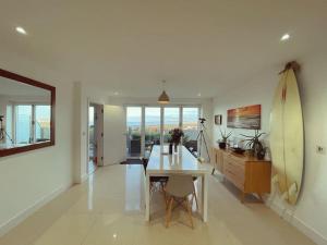 a living room with a table and a surfboard at Thorndale - Luxury Coastal Home - Hot Tub , Cinema & Games Room in Westward Ho