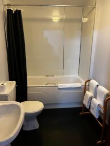 a bathroom with a tub and a toilet and a sink at The Stag Hotel in Banchory