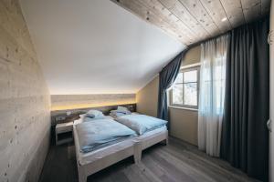 A bed or beds in a room at Seiser Alm Urthaler