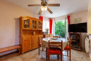 a dining room with a table and a ceiling fan at Appartement dans cadre de verdure in La Seyne-sur-Mer