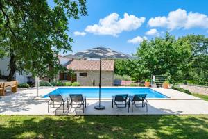 a pool with chairs and a table and a house at Casa Ana Tripari by Briskva in Višnjan