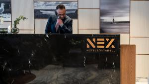 a man talking on a cell phone in front of a building at Nex Hotel & Spa Istanbul in Istanbul