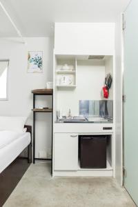 mała kuchnia ze zlewem i kuchenką mikrofalową w obiekcie 小さなお部屋 フクギStyle w mieście Miyako-jima