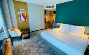 a hotel room with a bed and a chair at SIHA Hotel & Casino in Sihanoukville +57 photos