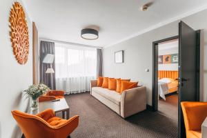 salon z kanapą i lustrem w obiekcie Hotel New Skanpol w Kołobrzegu