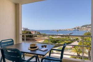 a table with a hat on a balcony with a view at Best Western Plus Ajaccio Amirauté in Ajaccio