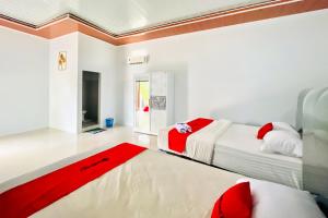 a bedroom with two beds and a red rug at RedDoorz at MG House Siantar Timur in Pematangsiantar