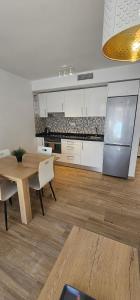 a kitchen with a table and a stainless steel refrigerator at Vitarka, ático del mar in Torre del Mar