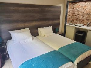 two beds sitting next to each other in a room at The Crooked Forest in Pretoria