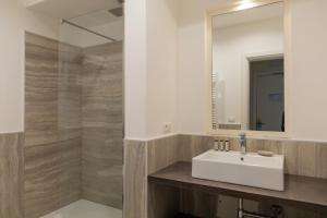 a bathroom with a sink and a mirror at Mosella Suite Hotel in Sottomarina