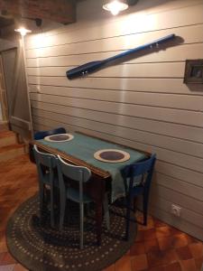 a table with chairs and a baseball bat on the wall at LA MAISON DU BOSCO in Auray