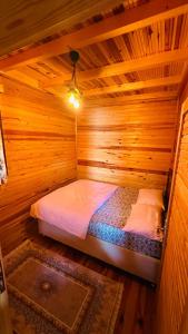 Habitación con cama en una cabaña de madera en Yeşilyurt dağ tesisi, en Yeniköy