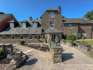 a large brick house with a garden in front of it at Pilgrim Hotel in Hereford