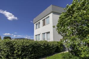 a white building with bushes in front of it at La Cordata Accommodation - Woodhouse Bike Hotel in Cinisello Balsamo