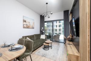un salon avec un canapé et une table dans l'établissement Resort Hevenia Mrzeżyno - Apartament 1, à Mrzeżyno