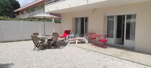 eine Terrasse mit Tisch, Stühlen und Sonnenschirm in der Unterkunft Chez Camille appartement spacieux 75m2 climatisation wifi parking terrasse et cour privative a 50 m de la plage in Le Grau-du-Roi