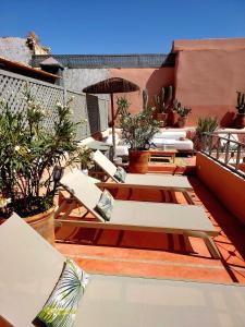a patio with chairs and plants on a roof at Riad Dar Zouar & Spa in Marrakech