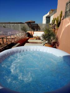 a hot tub with blue water in a backyard at Riad Dar Zouar & Spa in Marrakech
