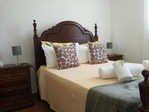 una camera da letto con un grande letto con molti cuscini di Casa Oliveirinha a Sagres