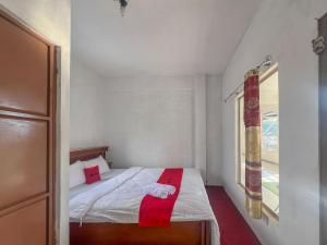 a small bedroom with a bed with a red towel on it at RedDoorz Syariah at Jalan Dieng 4 in Kejajar