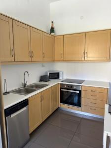 a kitchen with wooden cabinets and a sink at Stone Steps Studio in Symi +11 photos
