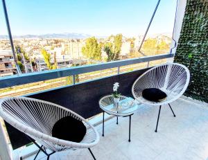 アテネにあるPanorama house near Teleperformanceのバルコニーに椅子2脚とテーブル1台