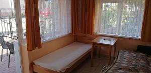 a small room with a bench in front of two windows at OLEŃKA in Darlowko