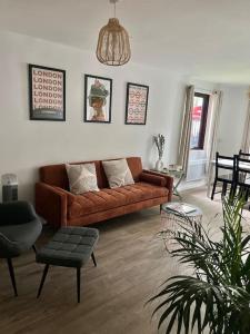 Una sala de estar con un sofá marrón y una mesa. en Gorgeous Flat 10 Min Walk to Stadium FREE parking, en Londres