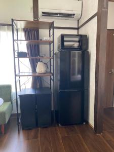 a living room with a microwave and a refrigerator at KAI 勝浦 Chiba in Katsuura