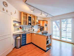 een keuken met houten kasten en een groot raam bij Haus Kormoran, Fewo Nr 9 in Zingst