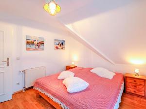een slaapkamer met een rood bed met 2 kussens bij Haus Kormoran, Fewo Nr 9 in Zingst