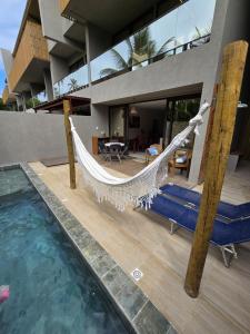 eine Hängematte auf der Terrasse eines Hauses mit Swimmingpool in der Unterkunft Kanui VK 102 Milagres - Duplex Perto da Capela e Raizeiros in São Miguel dos Milagres
