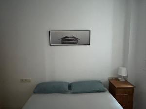 a bedroom with a bed and a picture on the wall at Céntrico apartamento a 150 metros de la playa. Parking* in Lloret de Mar