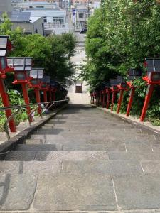 a walkway with red posts and trees in a city at KAI 勝浦 Chiba in Katsuura