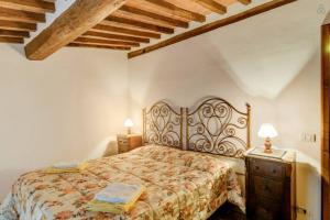 a bedroom with a bed and a dresser with two lamps at Case dei Fiori Residenza Storica in Torrita di Siena