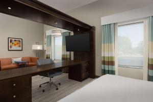 a hotel room with a desk and a television at Hampton Inn & Suites Huntsville Research Park Area in Huntsville
