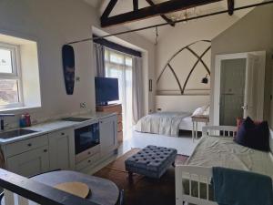 a bedroom with a bed and a bathroom with a sink at Loft Barn Apartment, sleeps 4 in Heath and Reach