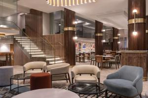 una hall con sedie, tavoli e una scala di Radisson Hotel Cape Town Foreshore a Città del Capo