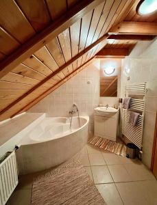 a large bathroom with a tub and a sink at Reichelhausen Vendégház in Kiskunhalas