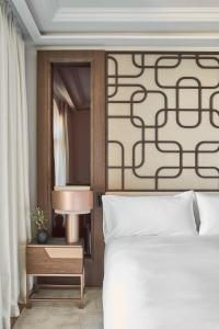 a bedroom with a white bed and a mirror at Nobu Hotel San Sebastián in Donostia-San Sebastián