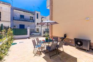 un patio con tavolo, sedie e ombrellone di Mary House by BarbarHouse a Taranto