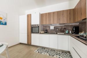 una cucina con mobili bianchi e un piano di lavoro di Mary House by BarbarHouse a Taranto