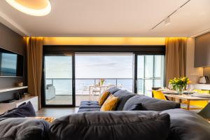 a living room with a couch and a view of the ocean at Apartament Dream View Gardenia Front in Dziwnów